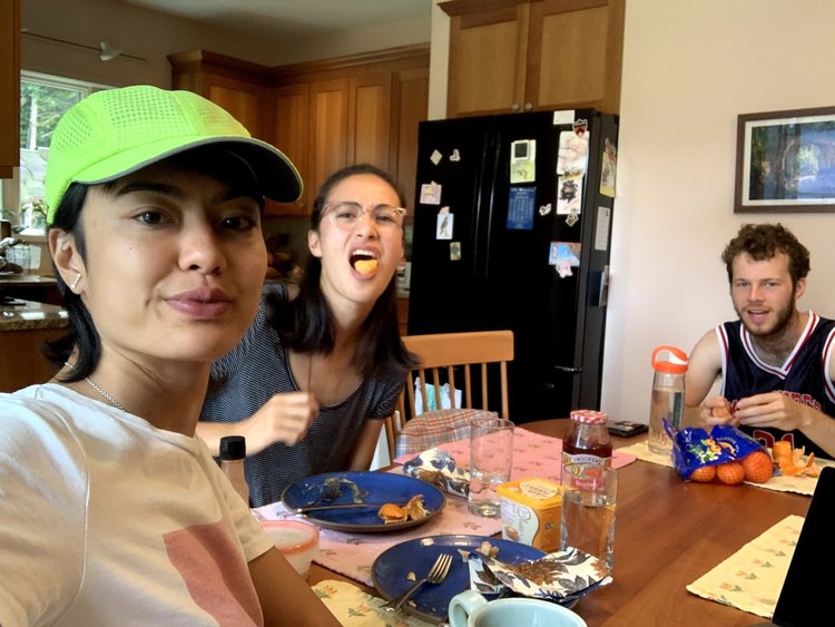Lesley taking a selfie while eating at a table with Maya and Akiva