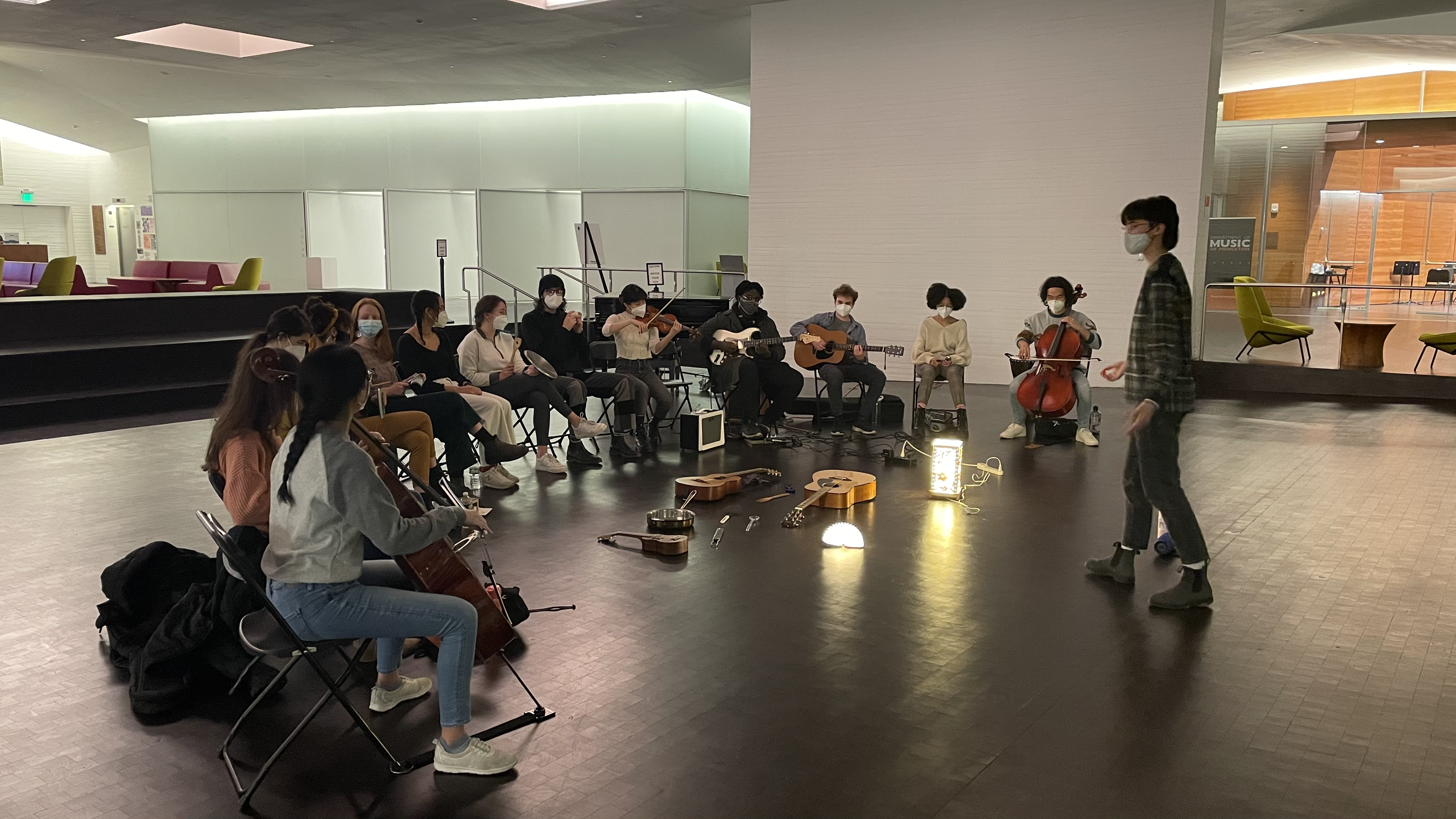 shot of conduction in action, participants seated in half circle while maya conducts